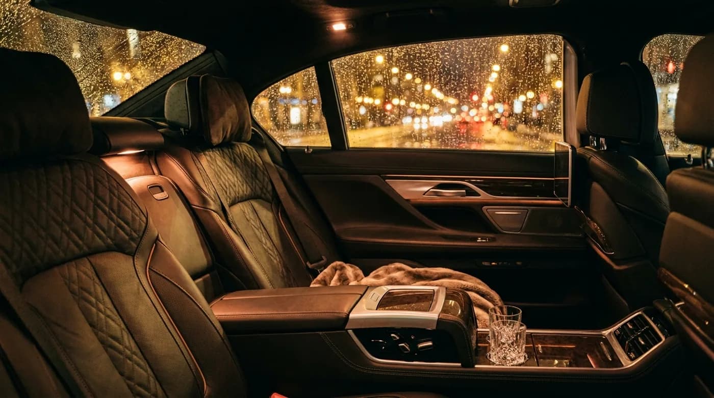Refined leather rear-seat interior of a luxury sedan at night with city lights