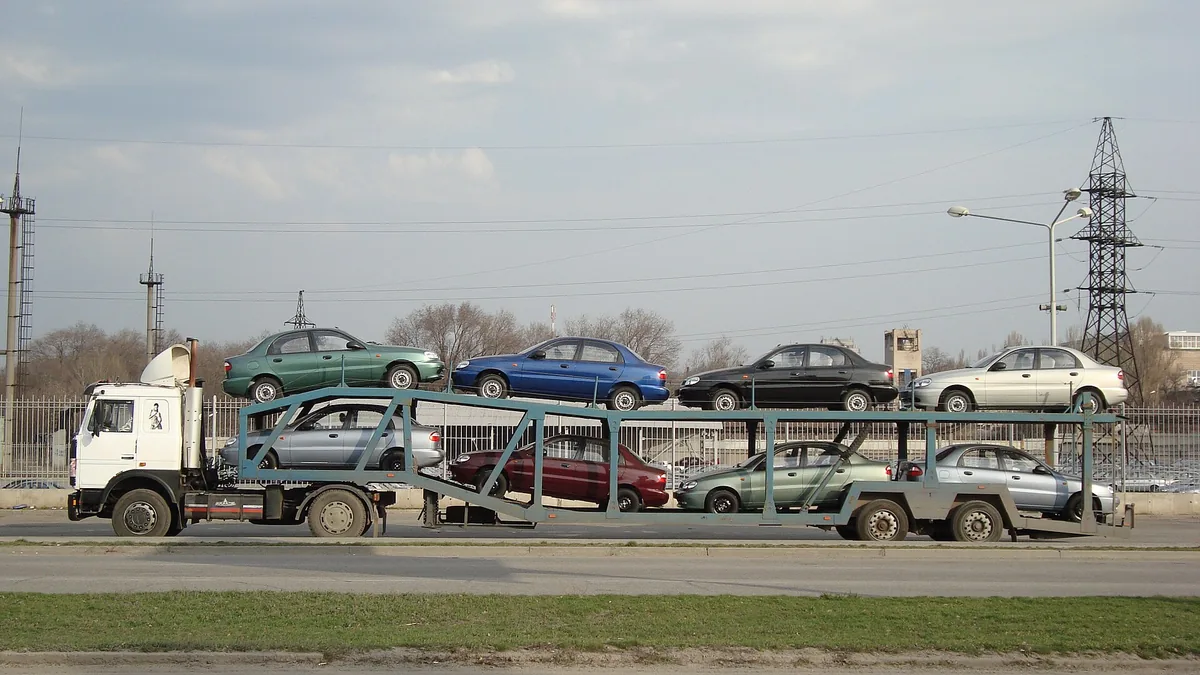 Coches en un camión portacoches en la autopista